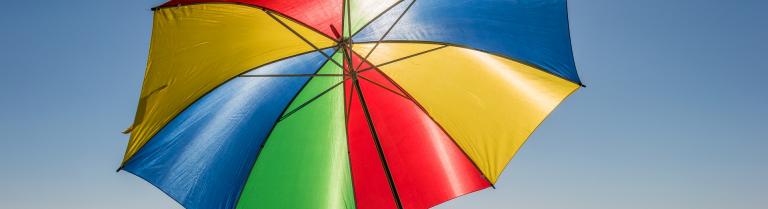 Bunter aufgespannter Sonnenschirm am Strand