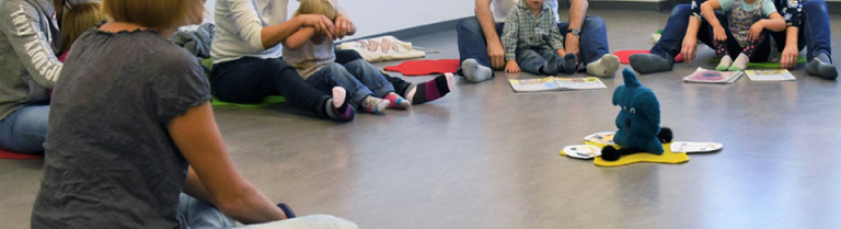 Eltern und Kleinkinder im Kreis sitzend