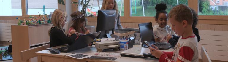 Kinder arbeiten mit Laptop und Handy