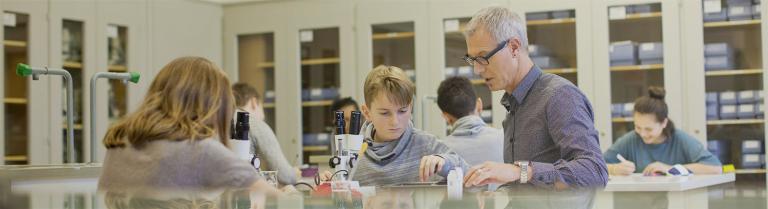 Schüler arbeiten mit Mikroskop 