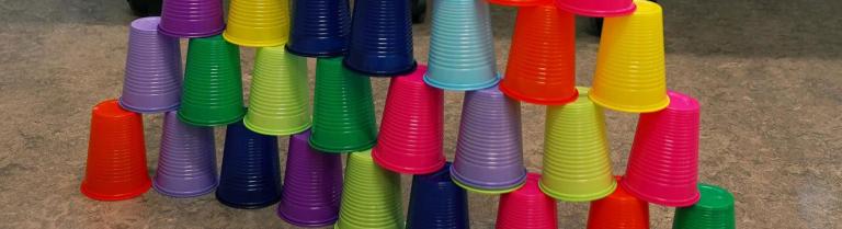 Farbige aufeinander gestapelte Trinkbecher als Teil eines Spiels am MATHEentdecken-Tag.