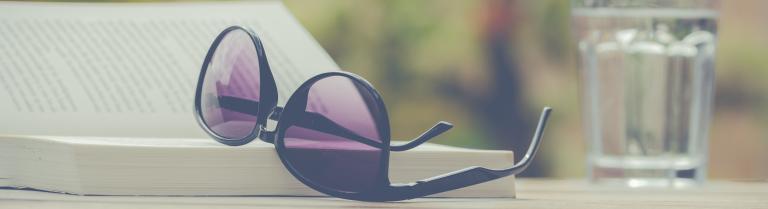 Eine Sonnenbrille liegt auf einem aufgeschlagenen Buch