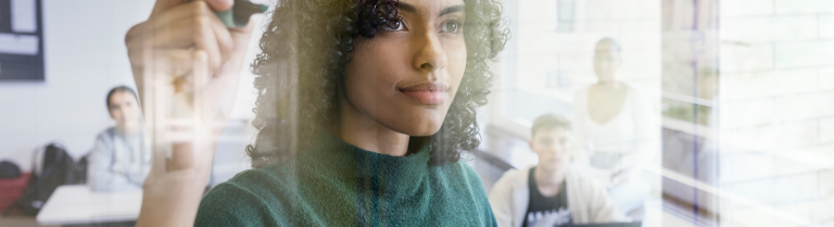 Eine Frau schreibt etwas auf eine Tafel