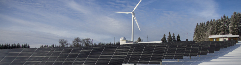 Windrad und Solarenergie in Winterlandschaft