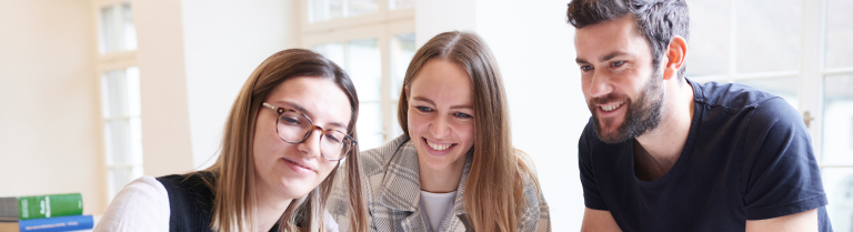 Studierende betrachten gemeinsam ein tablet