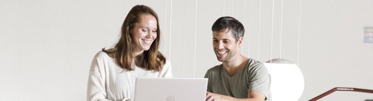Mann und Frau mit Laptop und Zertifikat in der Hand