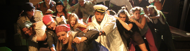 Mehrere Personen bewegen sich auf einer Bühne in eine Richtung