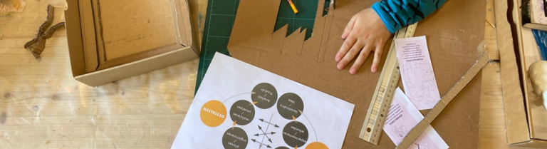 Junge welcher aus Karton Formen ausschneidet