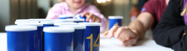 Kind und Mann stellen blaue Becher auf