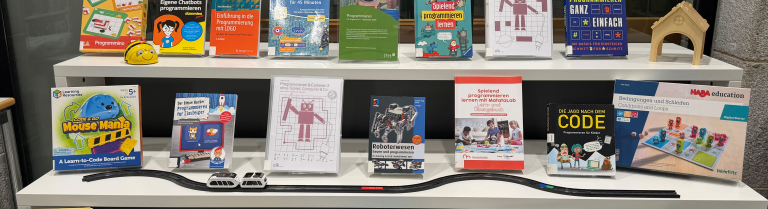 Ein Bücherausstellungsregal mit verschiedenen Medien zum Thema «Programmieren»