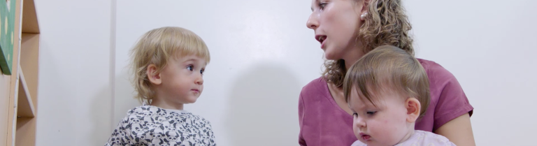 Fachperson spricht mit einem Kinder über ein Bilderbuch