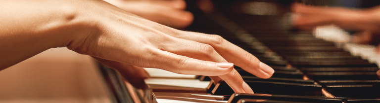 Frauenhände spielen auf einem Klavier