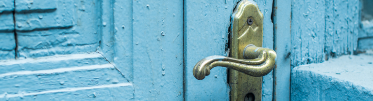 ein Türgriff an einer türkisfarbenen Tür