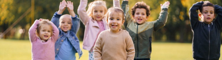 eine Gruppe Kinder bewegt die Arme im Freien
