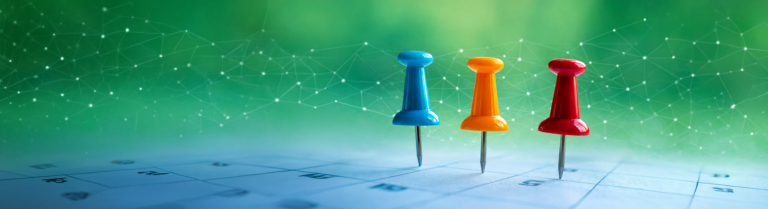 Drei bunte Pins auf einem Kalender als Symbol für aktuelle KI-News und Veranstaltungen des IDIB