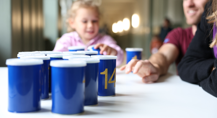 Kind und Mann stellen blaue Becher auf