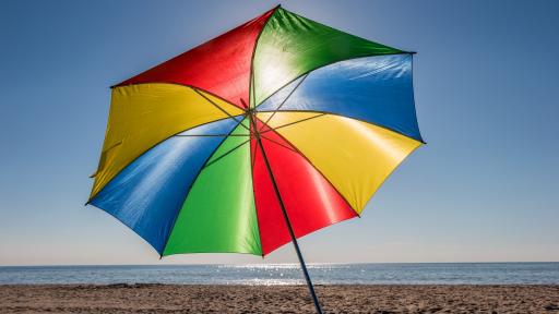 Bunter aufgespannter Sonnenschirm am Strand