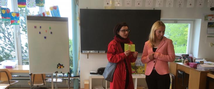 Zwei Frauen stellen Bilderbücher im Asylzentrum vor
