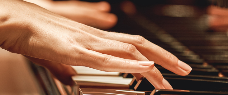 Frauenhände spielen auf einem Klavier