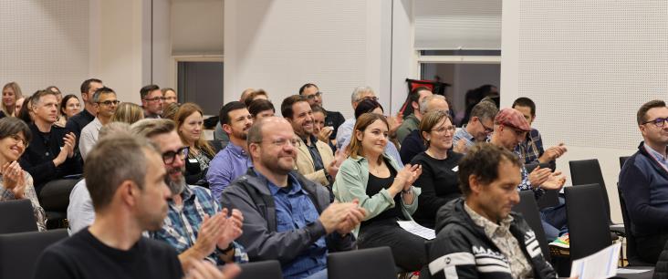 Die Teilnehmenden des Netzwerktreffens 2022 applaudieren nach einer Keynote.