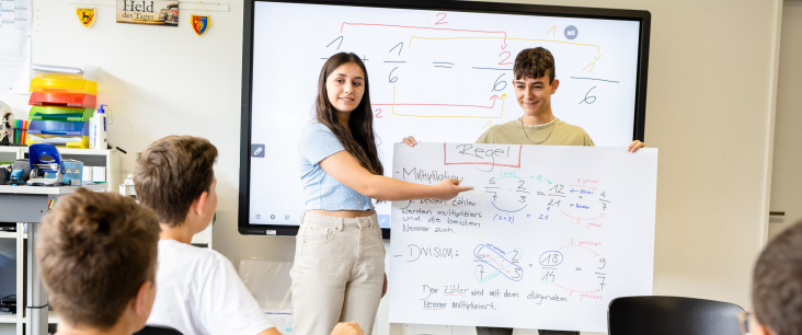 Sekundarschülerin und -schüler präsentieren ein Plakat