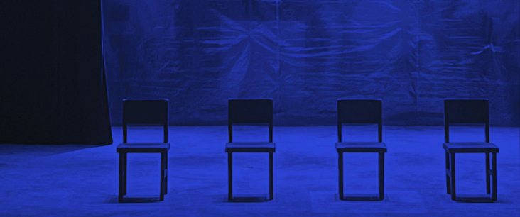 eine leere Theaterbühne, die in blaues Licht getaucht ist