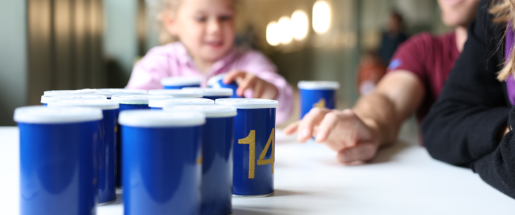 Kind und Mann stellen blaue Becher auf