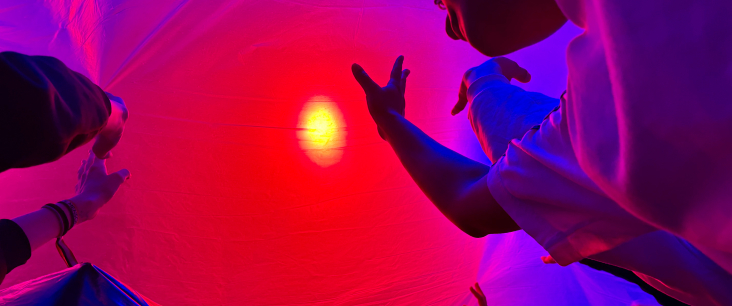 Jugendliche recken sich einem Licht entgegen