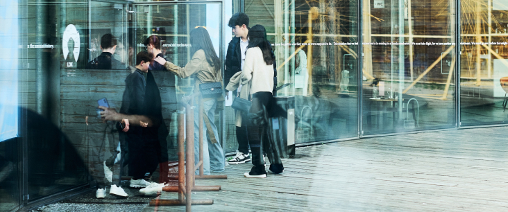 Mehrere Jugendliche gehen durch eine Glastür