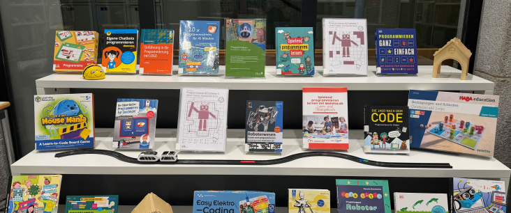 Ein Bücherausstellungsregal mit verschiedenen Medien zum Thema «Programmieren»