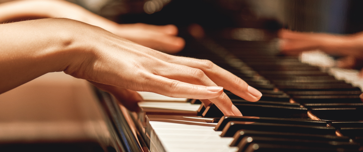 Frauenhände spielen auf einem Klavier