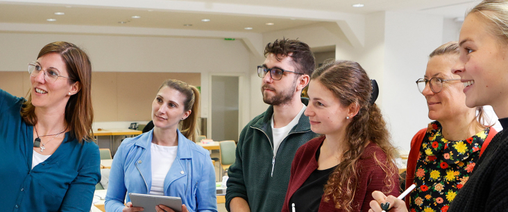 Dozentin zeigt den Student:innen etwas am Flipchart