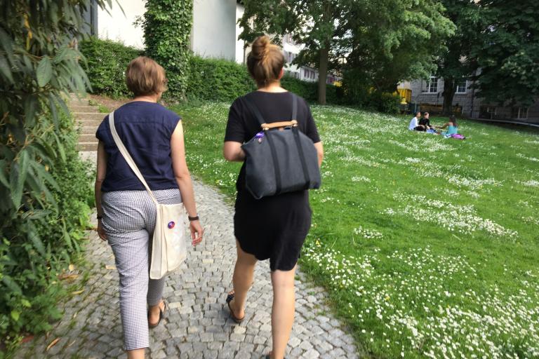 Zwei Frauen gehen einen Wiesenweg entlang