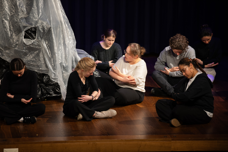 Mehrere Personen sitzen auf einer Bühne