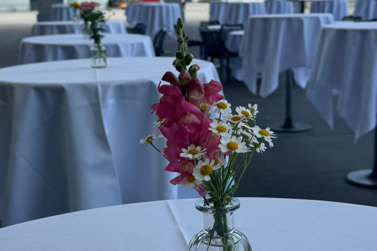 Kleine Vase mit Blumen auf einem Stehtisch