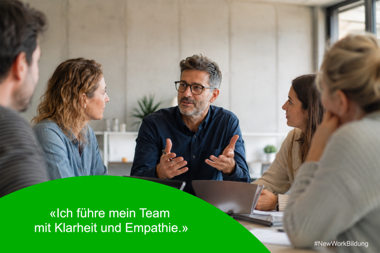 Schulleiter im Gespräch mit einem kleinen Team am Tisch als Symbol für New Leadership und Teamdynamik
