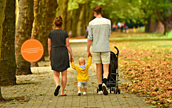 Elternpaar spaziert mit Kind in der Mitte im herbstlichen Park