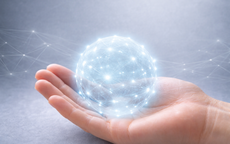 Hand hält leuchtende digitale Vernetzungskugel als Symbol für KI-Angebote des IDIB