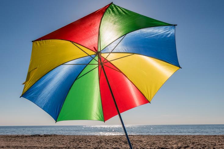 Bunter aufgespannter Sonnenschirm am Strand