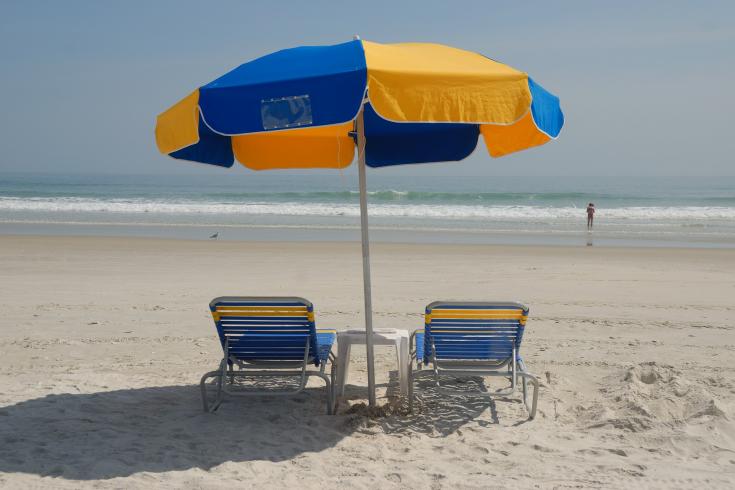 Zwei Liegestühle mit Sonnenschirm am Strand