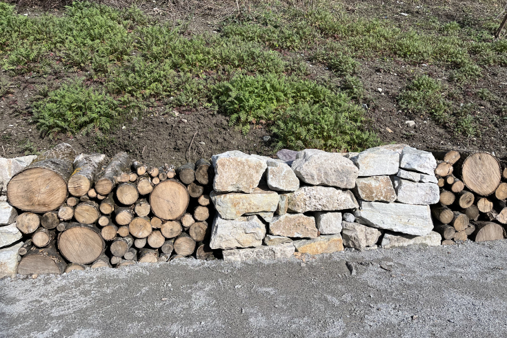 Mauer aus Steinen und Baumstämmen