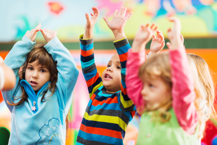 Kleine Kinder strecken ihre Arme in die Luft
