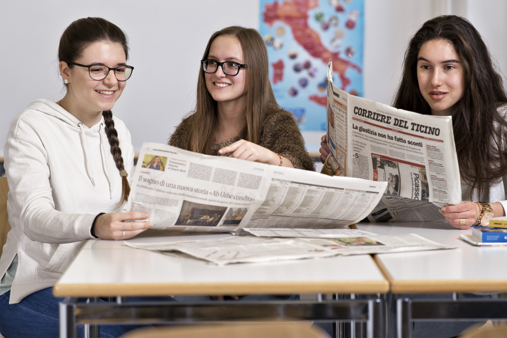 drei Mädchen lesen Zeitung