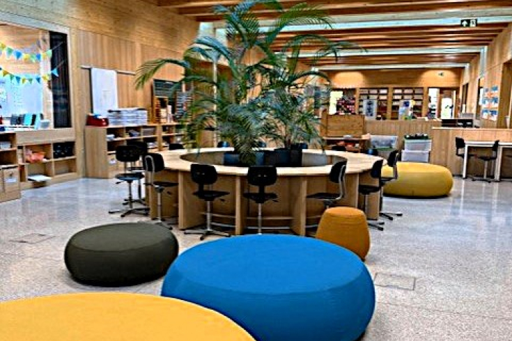 innovativer Schulraum mit Palme, Pouf, Nischen