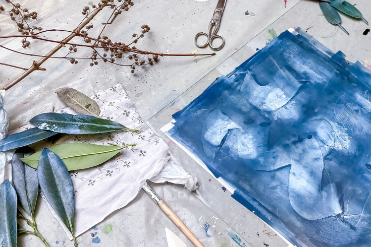 Kunst in blauer Farbe mit Blättern