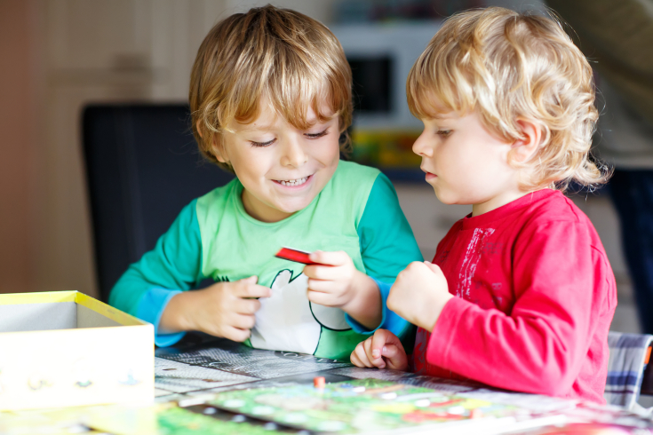 Zwei Kinder betrachten ein Schild, das zu ihrem Spiel gehört