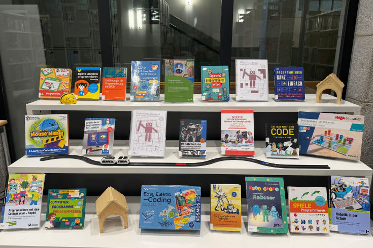 Ein Bücherausstellungsregal mit verschiedenen Medien zum Thema «Programmieren»