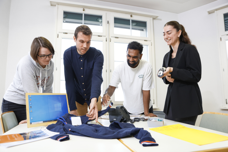 eine Gruppe Studierende steht an einem Pult